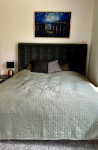 um quarto com uma grande cama branca com uma fotografia na parede em Appartement Louis em Oberammergau