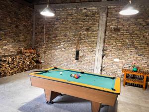 a pool table in a room with a brick wall at Świerkowy Domek pod Aniołem in Łapy