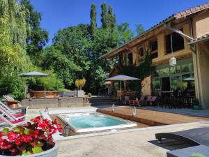 a backyard with a swimming pool and a house at Lili Paradis in Saint-Savin