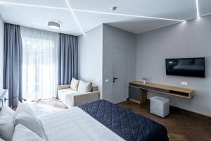 um quarto de hotel com uma cama e uma televisão em OTAMAN Resort em Lviv
