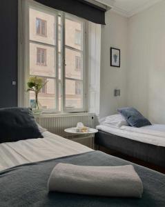 a hotel room with two beds and a window at Lilla Brunn in Stockholm