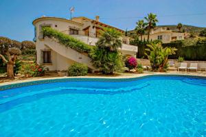 una gran piscina frente a una casa en Nessa - well furnished villa with panoramic views in Benitachell, en Benitachell