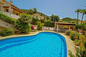a swimming pool in front of a house at Nessa - well furnished villa with panoramic views in Benitachell in Benitachell