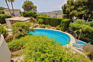 una piscina en un jardín con arbustos y árboles en Nessa - well furnished villa with panoramic views in Benitachell, en Benitachell