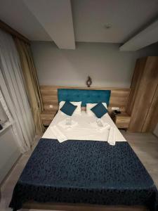 a bedroom with a large bed with blue sheets and pillows at Destinia Pera Suites in Istanbul