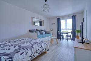 a bedroom with a bed and a living room at Logement Elia in Evry-Courcouronnes