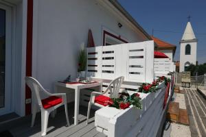 a patio with a table and chairs and a church at EHM Resort Mesteri in Mesteri