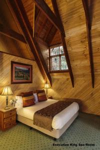 1 dormitorio con 1 cama en una cabaña de madera en Mt Tamborine Stonehaven Boutique Hotel, en Mount Tamborine