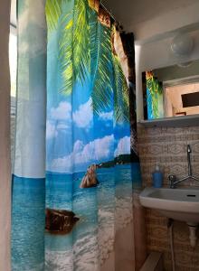 a bathroom with a shower curtain with a view of the ocean at Santa Marina Rooms in Agia Marina Aegina