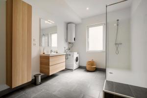 a bathroom with a sink and a washing machine at Magnifique appartement plein centre, calme, Netflix in Mirepoix