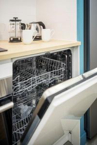 a dishwasher with two cups in it in a kitchen at Magnifique appartement plein centre, calme, Netflix in Mirepoix
