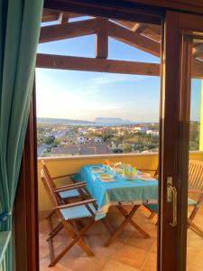 a table and chairs on a balcony with a view at La PAVONCELLA sul MARE in Tanaunella