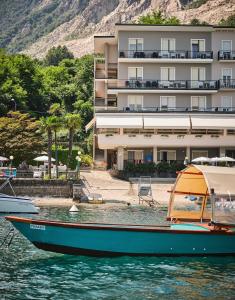 un barco en el agua frente a un edificio en Hotel Carillon en Baveno