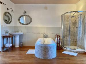 ein Badezimmer mit einer Badewanne und einem Waschbecken in der Unterkunft Château de la Preuille Bed & Breakfast in Montaigu-Vendée