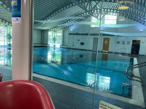 uma grande piscina num edifício com uma cadeira vermelha em lake view staycations em Carnforth