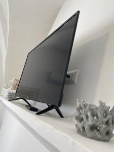 una TV a schermo piatto seduta su uno scaffale di Le dimore del salento appartamento 2 a Tricase