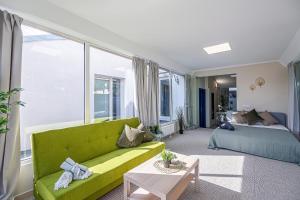 uma sala de estar com um sofá verde e uma cama em The house Kaunas em Kaunas