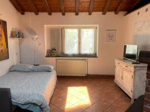 a bedroom with a bed and a tv and a window at Casetta di Chri in Chiavari