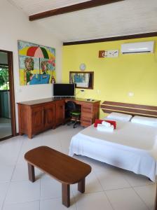 a hotel room with a bed and a desk and a desk at Pousada Vila das Flores in Morro de São Paulo