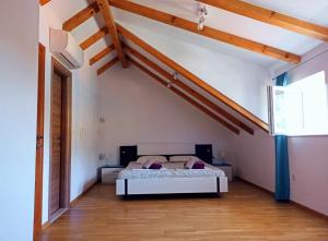 - une chambre avec un lit dans une pièce dotée de plafonds en bois dans l'établissement Villa Tanya - modern 3 bedroom house seconds away from the sea, à Zaton