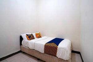 Un dormitorio con una cama con almohadas de colores. en SPOT ON 91394 Pondok Paskal Syariah en Bandung