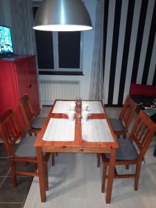 einem Holztisch mit zwei Tassen darauf mit Stühlen in der Unterkunft Czarna Góra Apartament in Stronie Śląskie