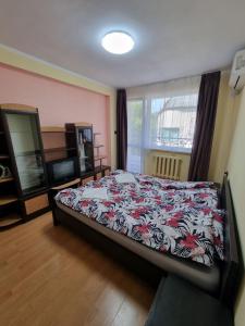 a bedroom with a bed with a floral bedspread at Apartment Lozenets in Sofia