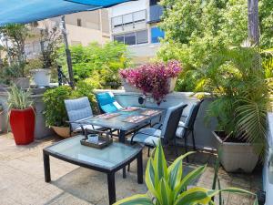 a patio with two tables and chairs and plants at Roof APT W terrace garden,1BR 1BA in Tel Aviv