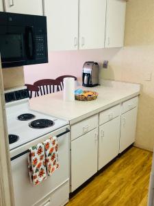 a kitchen with a white stove and a microwave at Beachfront Serenity Private Balcony with Ocean View, Shared Heated Pool and BBQ in New Smyrna Beach