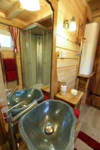 ein Bad mit 2 Waschbecken und einer Dusche in der Unterkunft EHM Baumhaus Chalet in Mesteri