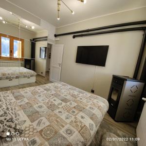 a bedroom with a bed and a flat screen tv at Casa di Nastya in Pretoro