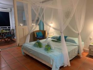 un dormitorio con una cama con dosel en LeLagon Vue Mer, Pieds dans l'eau, en Saint-François