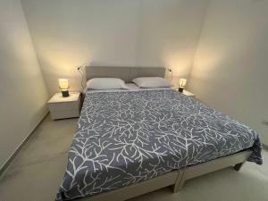 una camera da letto con un letto con due lampade su entrambi i lati di Le dimore del salento appartamento 2 a Tricase