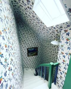 a childs room with a staircase with floral wallpaper at Aobrio Holidayhouse, old farmhouse close to Flåm in Lærdalsøyri