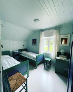 um quarto azul com duas camas e uma janela em Aobrio Holidayhouse, authentic norwegian farmhouse close to Flåm em Laerdalsoyri