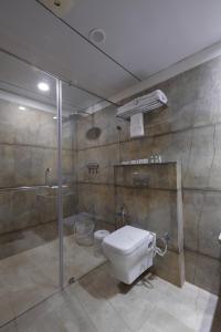 a bathroom with a toilet and a shower at HOTEL THE LOTUS PARK in Ahmedabad