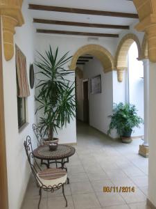 un patio con mesa, sillas y plantas en Hostal Fenix en Jerez de la Frontera