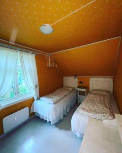 Duas camas num quarto com paredes cor de laranja em Aobrio Holidayhouse, authentic norwegian farmhouse close to Flåm em Laerdalsoyri