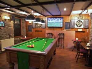 a billiard room with a pool table and a tv at Lion and Unicorn Hotel in Thornhill