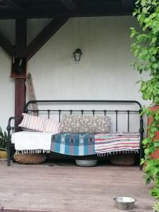 a bench with blankets and pillows on a patio at Wyciszek - mazurska agroturystyka in Węgorzewo