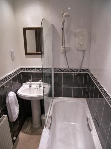 a bathroom with a shower and a sink and a tub at Lion and Unicorn Hotel in Thornhill