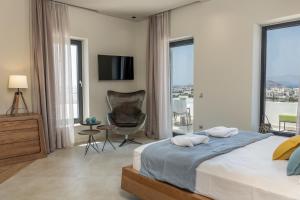 1 dormitorio con 1 cama, 1 silla y ventanas en El Mar Naxos en Naxos