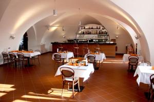 a restaurant with white tables and chairs and a counter at Hotel Zámek Velká Bystřice in Velká Bystřice