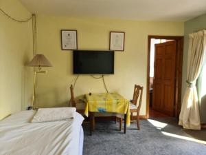 a bedroom with a table and a tv and a bed at Never to be booked in York