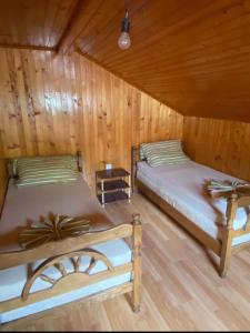 zwei Betten in einem Zimmer mit Holzwänden in der Unterkunft Sun-Love in Sutomore