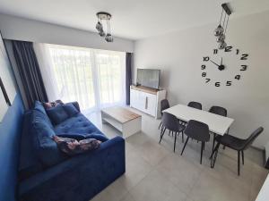 un soggiorno con divano blu e tavolo di Apartamenty Morze u Sary a Dziwnówek