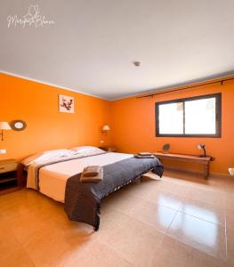 ein Schlafzimmer mit einem großen Bett mit orangefarbenen Wänden in der Unterkunft B-Rent Mariposa Private Garden in Corralejo