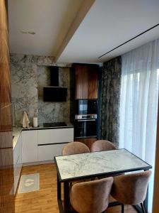 uma cozinha com mesa e cadeiras num quarto em Olives Residence em Dhërmi
