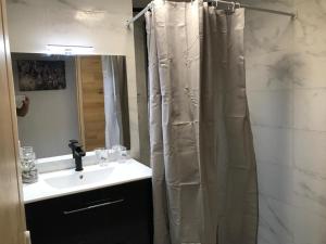 a bathroom with a shower curtain and a sink at Le Flamboyant avec piscine chauffée 30° et Jacuzzi in Saint-André