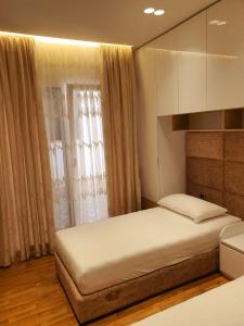 um quarto com uma cama grande e uma janela em Olives Residence em Dhërmi